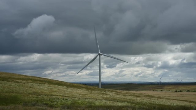 Time-lapse of wind turbine on a windy day with clouds passing by