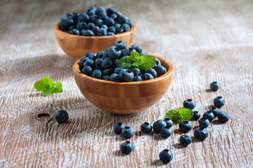Fototapeta na wymiar Blueberries in bowls, rustic style, wooden background, selective focus