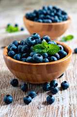 Blueberries in bowls, rustic style, wooden background, selective focus