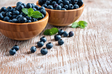 Blueberries in bowls, rustic style, wooden background, selective focus