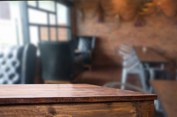 Selected focus empty brown wooden table and Coffee shop blur bac