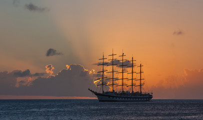 Large tall ship at sea during sunset.