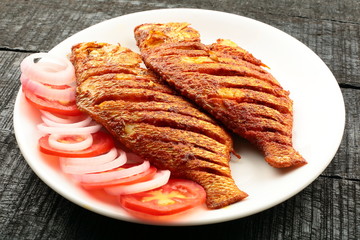 Plate of tasty and spicy fried fish