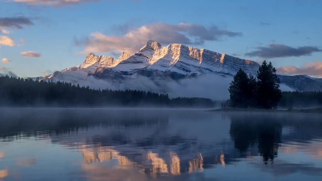 Rundle Mountain reflecting in Two Jack Lake in Banff National Park at sunrise. 