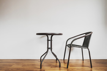 Modern interior space, white wall and laminated wood flooring with chair and table