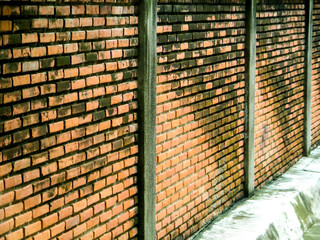 ancient brick wall beside way after rain fall