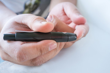 Close up of  male finger patient pricking his finger to draw a d