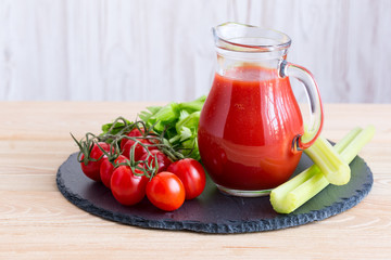 Tomato juice in a glass jar on wooden table.
