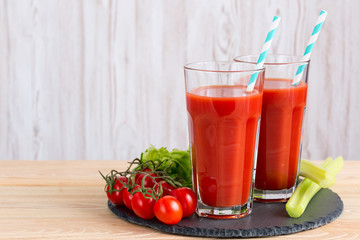 Tomato juice in a glass on wooden table.