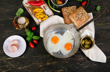 Fried eggs on a dark wooden table for Healthy breakfast.