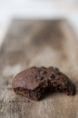 Chocolate chip cookies and glass of milk on wooden plate