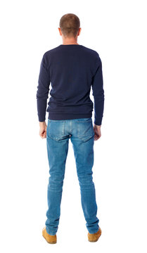 Back view of man in jeans. Standing young guy. Rear view people collection.  backside view of person.  Isolated over white background.  A guy in a black sweater standing with her hands down.