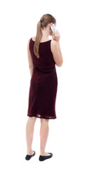Fototapeta premium back view of a woman talking on the phone. backside view of person. Rear view people collection. Isolated over white background. A girl in a burgundy dress talking on the phone.