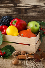 Fallen leaves, winter squash and vegetables in a wooden box