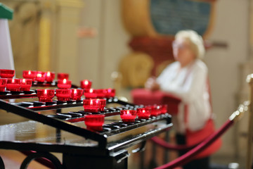 Old woman praying in a church on the knees