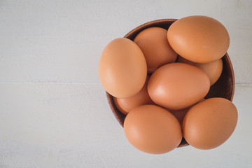 Egg in a wooden bowl on wooden table white. Chicken Egg. Top view with copy space