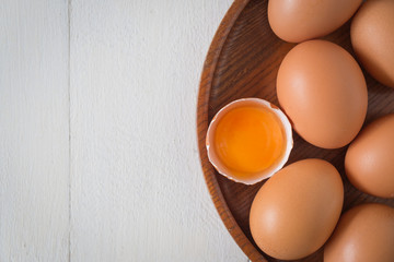 Egg in a wooden bowl on wooden table white. Chicken Egg. Top view with copy space