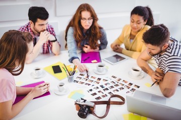Editors discussing pictures in meeting at creative office
