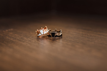 Golden wedding rings with crown shape on wooden background. Shallow focus