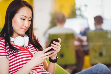 Beautiful businesswoman using cellphone at creative office