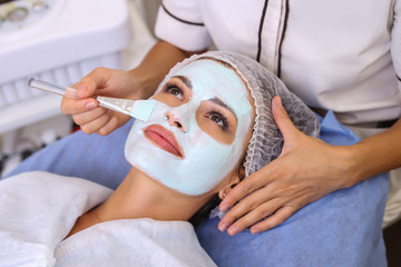 Beautiful woman with facial mask at beauty salon