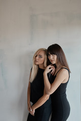 Obraz premium Two pretty woman in a black dress indoor