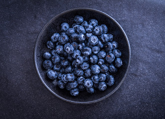  fresh picked blueberries on black stone background