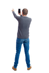 back view of standing young man  and using a mobile phone. girl watching. Rear view people collection.  backside view of person.  Isolated over white background. A guy in a gray sweater photographs