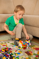 young boy playing with blocks on the ground in living room