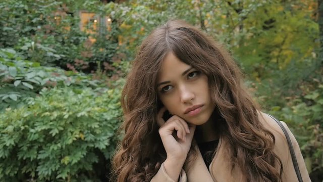 Beautiful girl is sad, in a park, slow motion