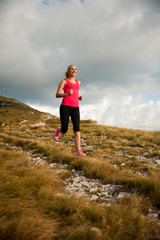 Naklejka na ściany i meble runner - woman runs cros country on a path in early autumn