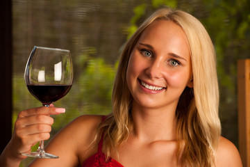 Beautiful woman drinks red wine outdoor on a hot summer afternoo