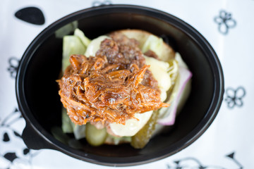 overhead shot of a burger in a plastic container