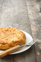 Traditional spanish omelette with potatoes and eggs on wooden table

