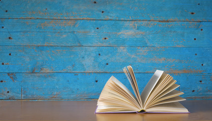 open book on blue grungy background