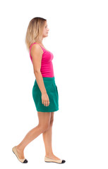 Fototapeta premium back view of walking woman. beautiful girl in motion. backside view of person. Rear view people collection. Isolated over white background. Girl in a green skirt is in the side.