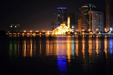Fototapeta na wymiar Colorful dancing fountain with mosque in the city at night with lively music, Sharjah, United Arab Emirates