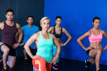 Papier Peint photo autocollant Fitness Determined athletes exercising in fitness studio