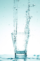 Obraz na płótnie Canvas water splash in glasses isolated on white