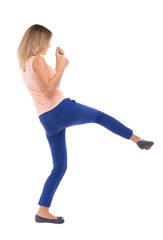 skinny woman funny fights waving his arms and legs. Isolated over white background. The blonde in a pink t-shirt has a foot.