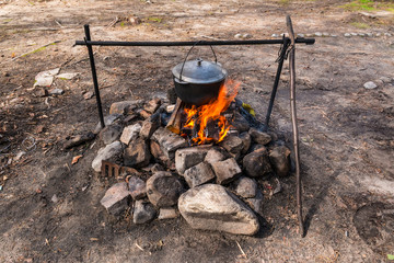 Cauldron hanging over the burning fire.