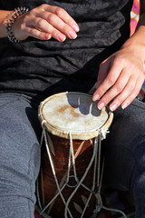 Close up of hands of a woman playing a drum