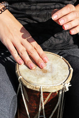 Close up of hands of a woman playing a drum