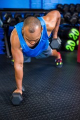 Fototapeta na wymiar Young man lifting dumbbells in gym
