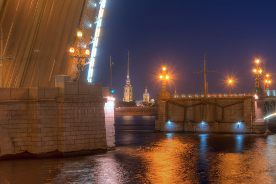 Night view of illuminated Neva River, open Trinity Bridge and Peter and Paul Cathedral between its wings, Saint Petersburg, Russia.