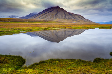 Reflection of mountain on small Arctic pond