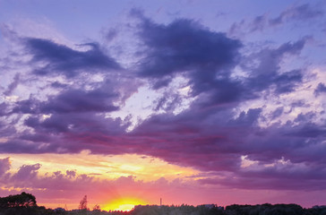 Fototapeta na wymiar Beautiful sunset through the evening cloudy sky/Beautiful sunset through the evening cloudy sky