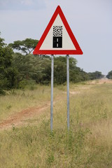 Traffic sign Attention! asphalt road changes abruptly to gravel road, Namibia Africa