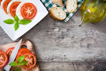 Caprese salad and ingredients on wooden background

