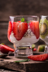 Healthy breakfast or morning snack with chia seeds granola, strawberries and kiwi, vegetarian food, diet and health concept